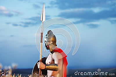 Strong Spartan warrior in battle dress with a shield and a spear Stock Photo