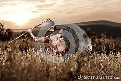 Strong Spartan warrior in battle dress with a shield and a spear Stock Photo