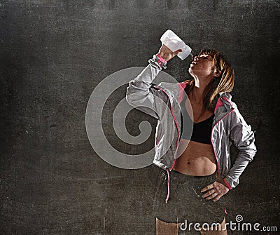 Strong sport freckles woman drinking water after training workout in gym club harsh light Stock Photo