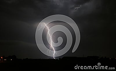 Bright branched lightning strike near an electricity mast from a severe thunderstorm in The Netherlands Stock Photo