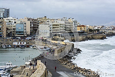 Strong waves and bay with ships on the background of the city and mountains in Greece Editorial Stock Photo