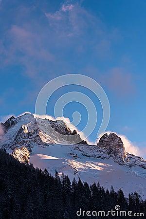 Strong wind blowing clouds over alpine peaks in winter Stock Photo