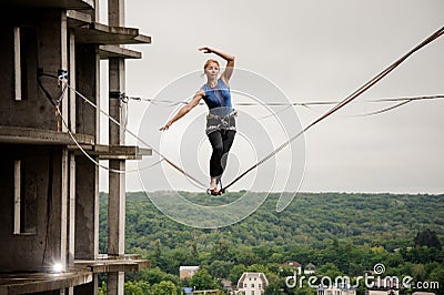 Strong and active young woman balancing on a slackline Stock Photo