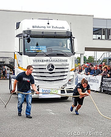 A strong woman pulls a heavy truck with a rope Editorial Stock Photo