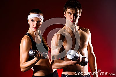 Strong young couple working out with dumbbells Stock Photo