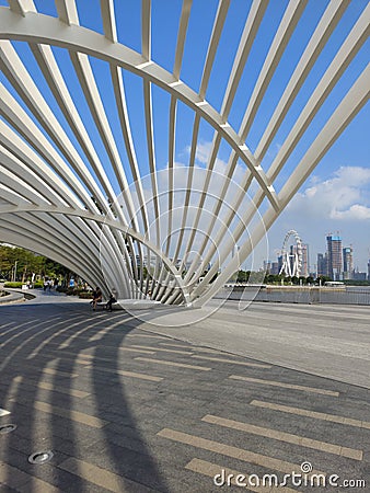 Structural artwork at a waterfront park overlooking the Ferris wheel and skyscrapers under construction Stock Photo