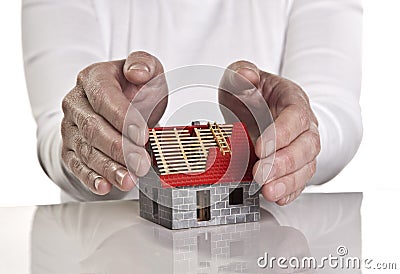 Hands protecting a house Stock Photo