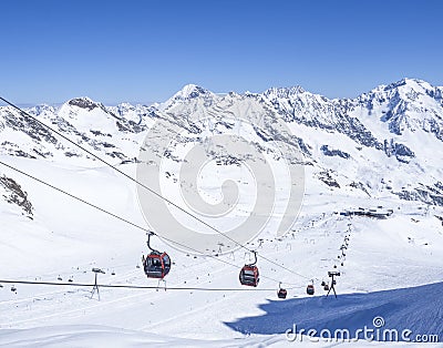 Stubai Glacier, AUSTRIA, May 2, 2019: Snow covered slopes with free rides and pistes and red Cable cars and chair lifts Editorial Stock Photo