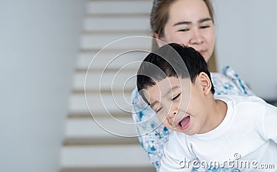 Stubborn little boy scream loud not listening to mom, while loving mother consoling or trying to make a peace Stock Photo