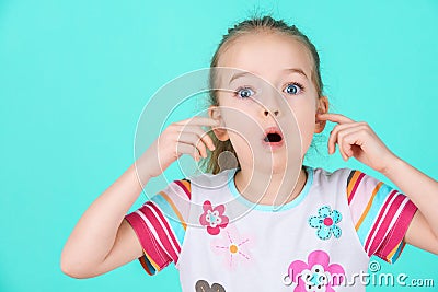 Stubborn little kid with an attitude ignoring parents, blocking her ears with hands. Stock Photo