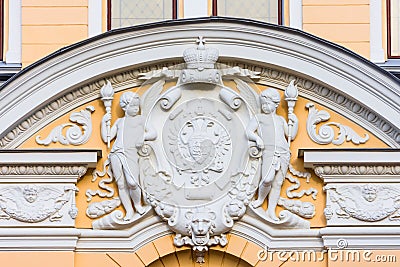 Stucco decoration over the arch - the coat of arms of the two-headed eagle of the Russian Empire with a crown, on the sides are tw Stock Photo