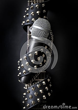 Studded belt, guitar neck and microphone. Stock Photo