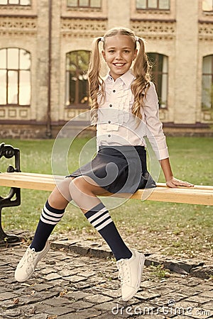 Student adorable child in formal uniform relaxing outdoors. Perfect schoolgirl relaxing between classes. Life balance Stock Photo