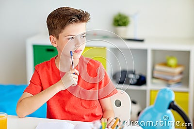 Student boy with pen and notebook thinking at home Stock Photo