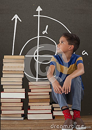 Student boy on a table looking up against grey blackboard with school and education graphic Stock Photo