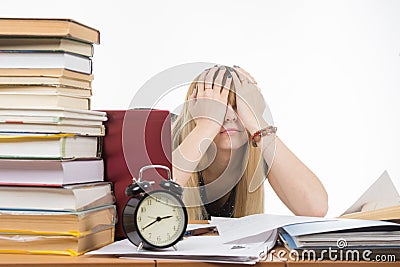 Student covering her eyes with her hands to take a break from their studies Stock Photo