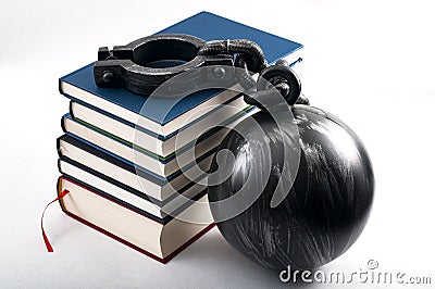 Student debt concept with a stack of books next to a ball and chain symbolizing the burden tuition costs represent isolated on Stock Photo