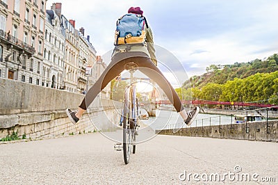 Young active woman riding a bicycle going down the road in the city Stock Photo