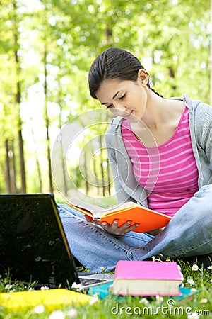 Student girl siting on grass in park Stock Photo