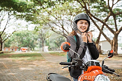 Student girl tightens helmet strap when going to ride Stock Photo