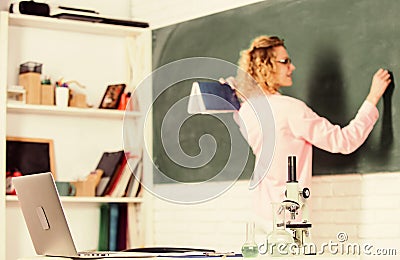 Student girl writing answer at blackboard. beaker and microscope. student doesnt use laptop. biology lesson. Science and Stock Photo