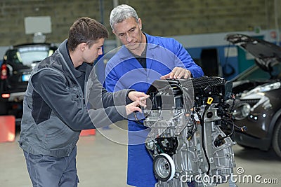 Student with instructor repairing car during apprenticeship Stock Photo