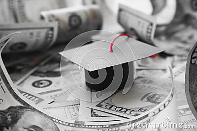Student Loan Debt With College Graduation Cap On Money In Black & White Stock Photo