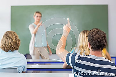 Student raising hand in classroom Stock Photo