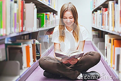 Student reading book in the library, smiling happy woman, education Stock Photo