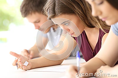 Student reading a cheating sheet during an exam Stock Photo