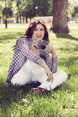 Student sitting in the park on the grass Stock Photo