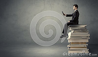 Student sitting on pile of books Stock Photo