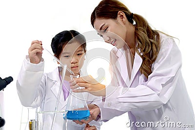 Student and teacher in lab coat have fun together while learn science experiment in laboratory. Young adorable Asian scientist kid Stock Photo