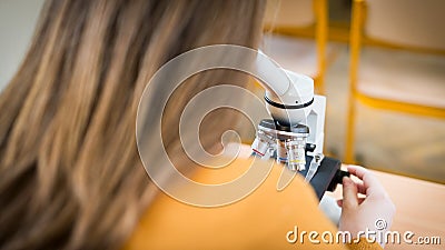 Student using microscope to examine samples in biology class. Stock Photo