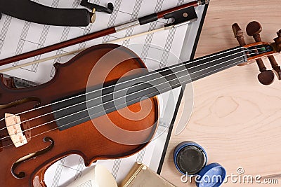 Student violin and folder with staves on wooden table top Stock Photo