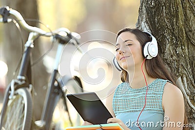 Student wearing headphones listening to music on line Stock Photo