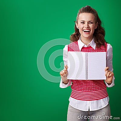 Student woman showing notebook blank page on green background Stock Photo