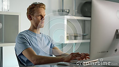 Student working studying home closeup. Confident ginger man writing check email. Stock Photo