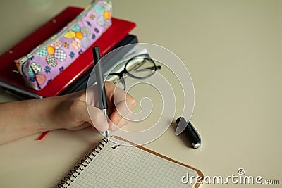 The student& x27;s hand writes with a pen in notebook Stock Photo