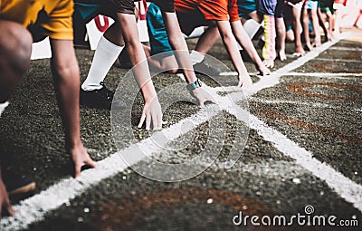 Students boy get set to leaving the starting for running competition boy at school sports day. Stock Photo