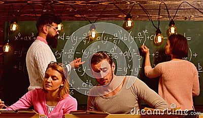 Students, group mates studying, while teacher asking girl near chalkboard. Exam concept. Bearded teacher, , professor Stock Photo