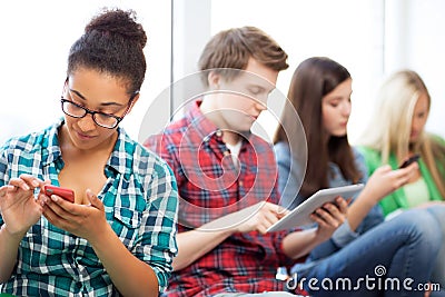 Students looking into devices at school Stock Photo