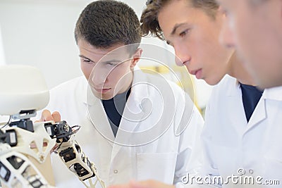 Students looking at robotic device Stock Photo