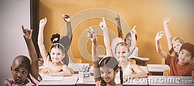 Students raising hands in classroom Stock Photo