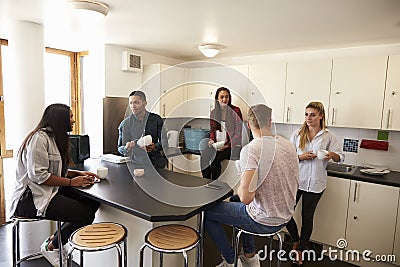 Students Relaxing In Kitchen Of Shared Accommodation Stock Photo