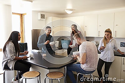 Students Relaxing In Kitchen Of Shared Accommodation Stock Photo