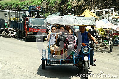 Students riding a tricycle to get to school Editorial Stock Photo