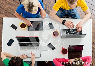 Students sitting at the table using computers Stock Photo