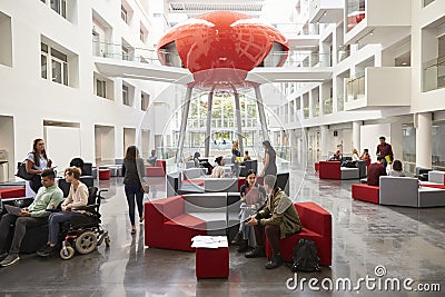 Students socialising in the modern lobby of their university Stock Photo