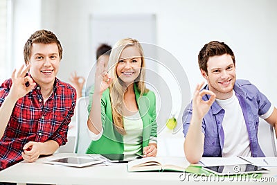 Students with tablet pcs showing ok sign Stock Photo